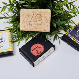 4 bathing bar pieces with 3 wrapped and 1 unwrapped and placed on greenery