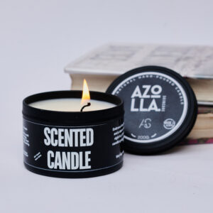 lit scented candle in black tin