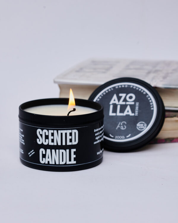 lit scented candle in black tin